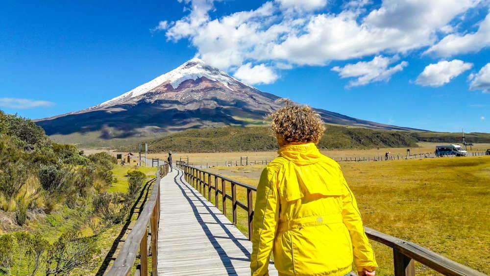 Mujer frente al volcán nevado en los Andes ecuatorianos